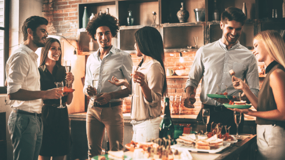 A woman holding a cocktail while looking at a man at an event party.