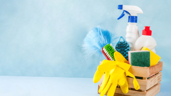 A basket full of cleaning products and rubber yellow gloves.
