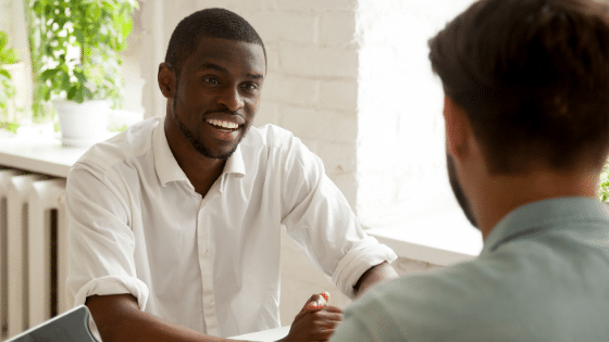 Two men sitting down conversing.
