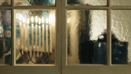 A menorah behind glass french doors.