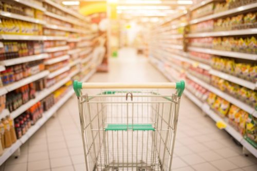 An empty grocery cart in a grocery store isle