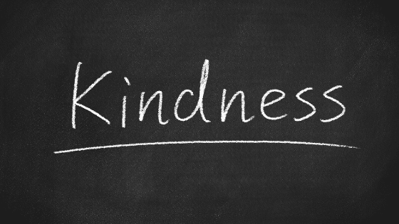 A black board with a text in chalk that says "kindness".