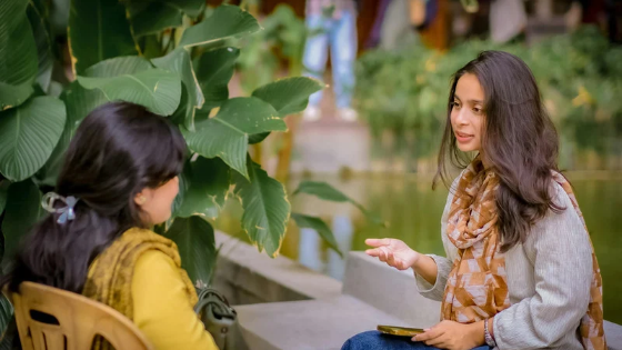 Two workplace leaders discussing a difficult topic during a team meeting